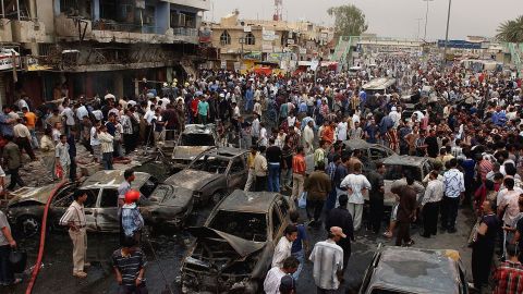People gather at the scene of a car bombing near a busy market in eastern Baghdad on May, 12, 2005.