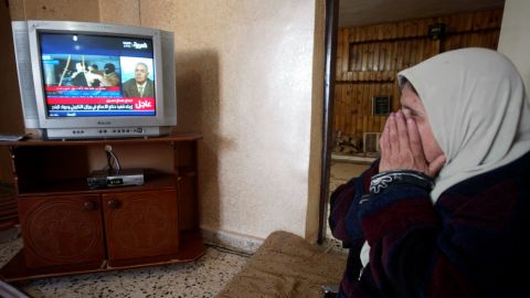 A Palestinian woman watches the news of Saddam Hussein's execution at her home in the West Bank town of Jenin on December 30, 2006. Hussein was hanged for his role in the 1982 Dujail massacre, in which 148 Iraqis were killed after a failed assassination attempt against the then-president.