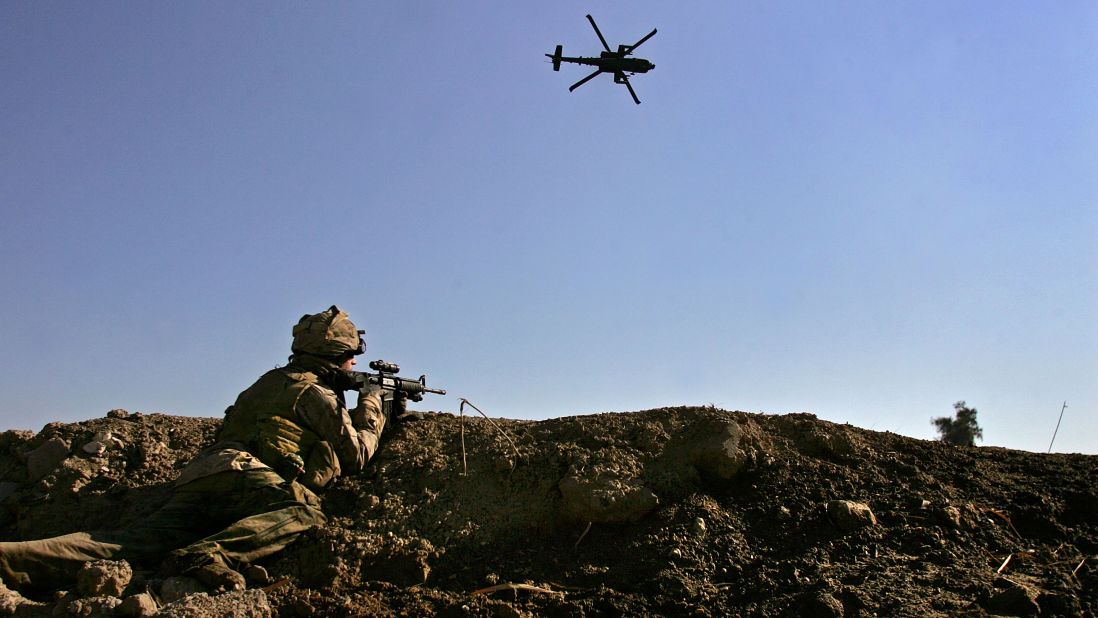 An American Apache helicopter provides air support while a Marine takes aim after being fired upon by insurgents near the Euphrates River in Ramadi on February 2, 2007.