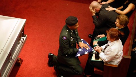 Army Brig. Gen. Nolen V. Bivens presents an American flag to Maribel Ferrero during the funeral of her 23-year-old son, Army Pfc. Marius L. Ferrero, in Miami. He was killed by a roadside bomb while serving in Iraq.