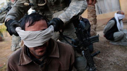 A U.S. soldier blindfolds an Iraqi man during a raid in Mukhisa on December 3, 2007.  Seven men were detained after multiple assault rifles were found in the house.