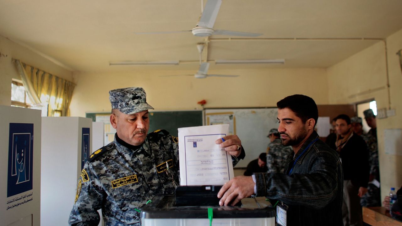 A poll worker helps a member of the Iraqi National Police cast his ballot in Baghdad on January 28, 2009. Polls were opened early to members of the Iraqi security services, many of whom would be working during the provincial elections.