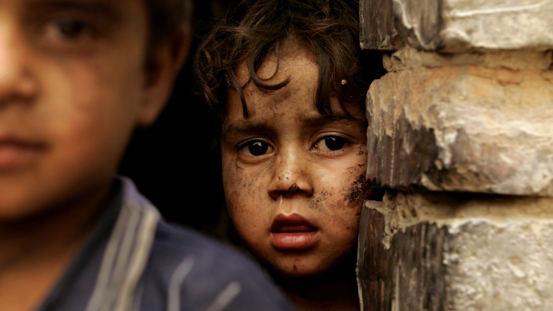 A boy looks out from his family shelter at a Narwan brick factory on July 1, 2008.