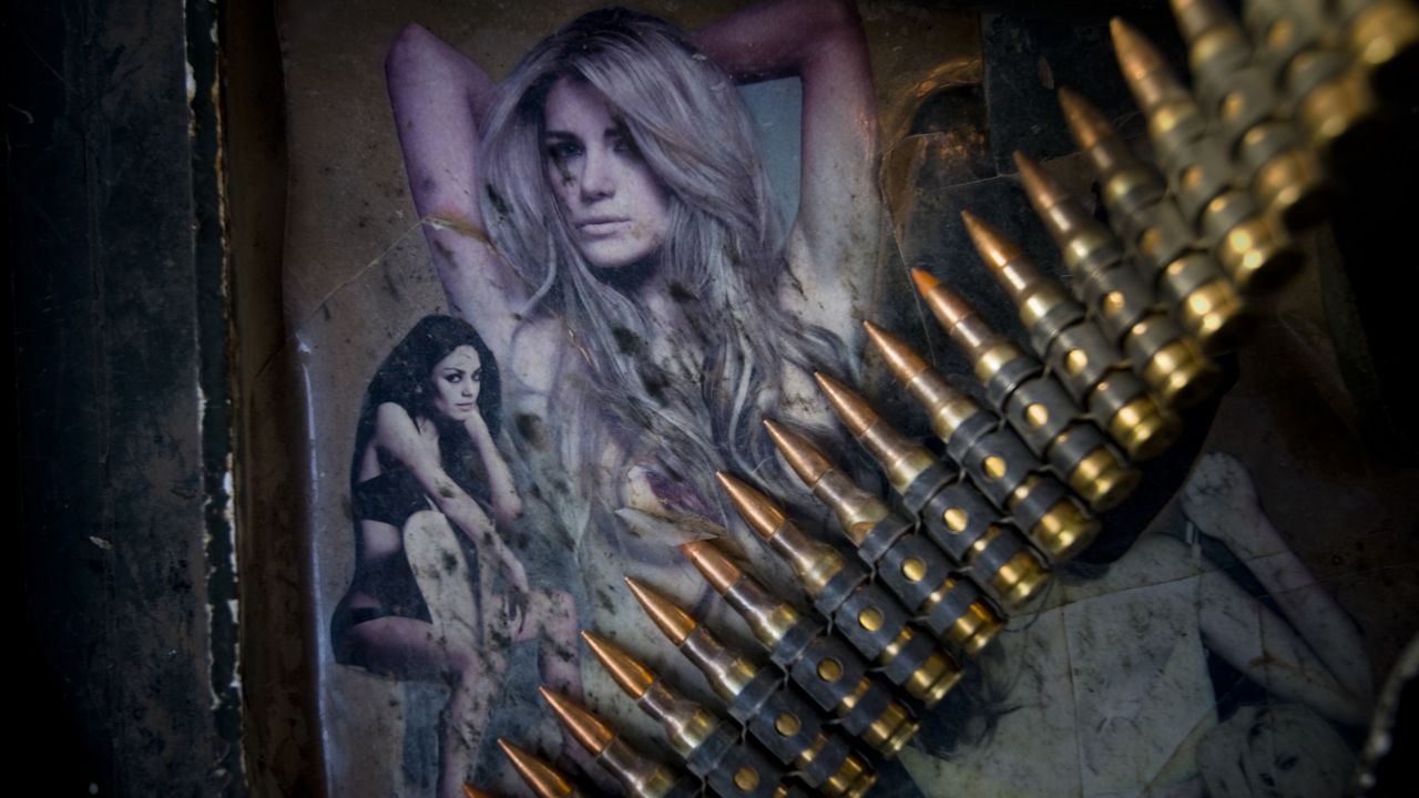 A string of bullets lies across photographs of women adorning the armor of a Stryker vehicle north of Jalaulah on June 11, 2010.