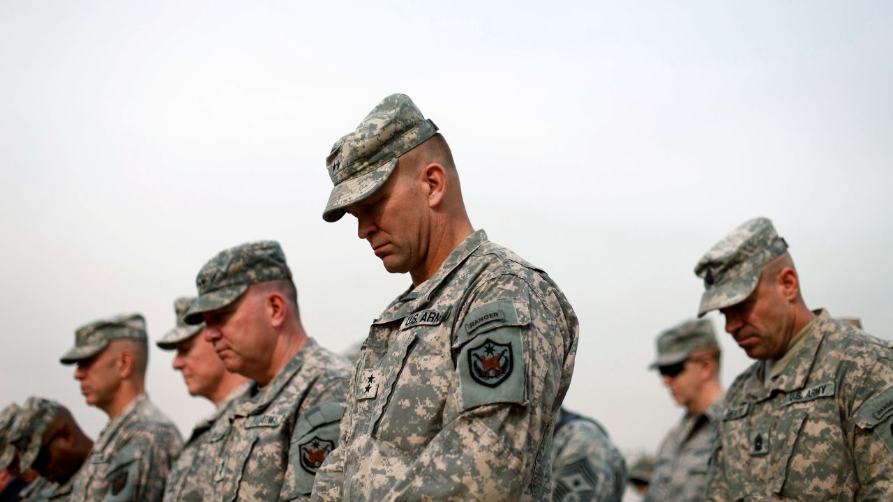 Military personnel lower their heads during the flag casing ceremony in Baghdad on December 15, 2011. The ceremony officially marked the end of U.S. military operations in Iraq.