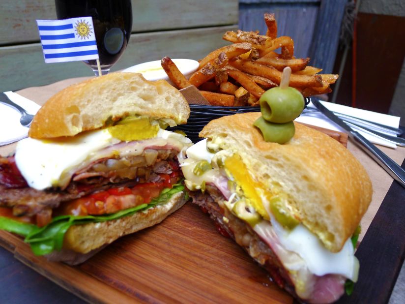 The Uruguayan chivito piles skirt steak or filet mignon with layers of ham and bacon, accompanied by onion, mayonnaise, lettuce, tomato, mozzarella, olives, hard-boiled egg and lettuce. Pictured: chivito from Tabaré in Brooklyn.