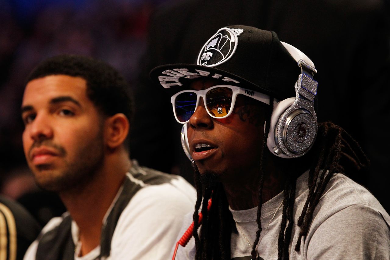 Lil Wayne and hip-hop artist Drake, left, sit courtside during the 2012 NBA All-Star Game.