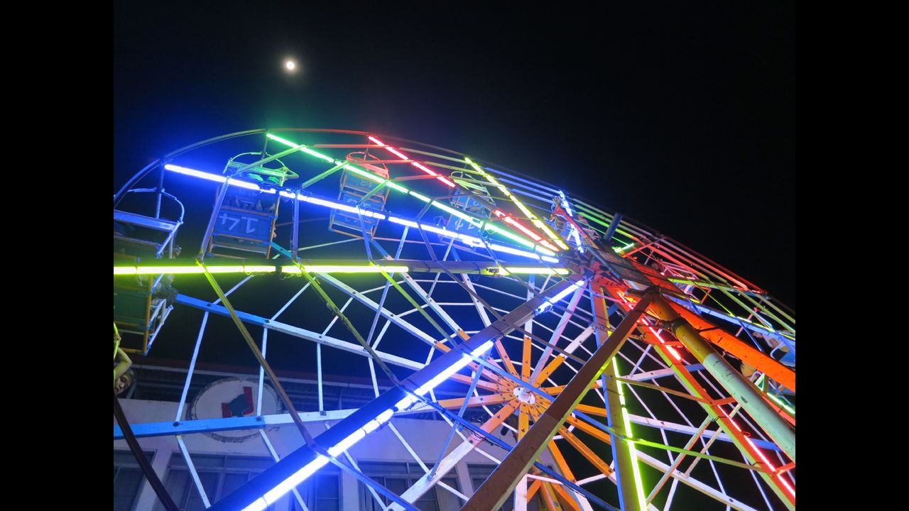 At a festival in Myanmar, Bourdain spots a unique carnival ride: a Ferris wheel driven by human power. He describes it as an "insanely dangerous, closely choreographed process of first getting the giant, heavily laden wheel in motion and then getting it up to top speed and keeping it there."