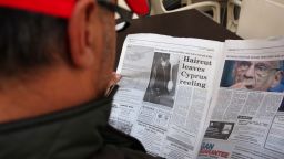 A man reads a newspaper at a cafe in the Cypriot capital Nicosia on March 17, 2013. 