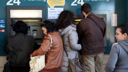 People withdraw money from a cash-point machine in the Cypriot capital Nicosia on March 17, 2013.