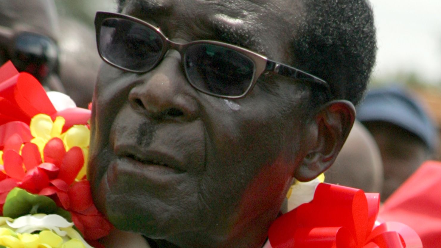 Zimbabwe's President Robert Mugabe wears a garland during a rally held on March 2, 2013 in Bindura,