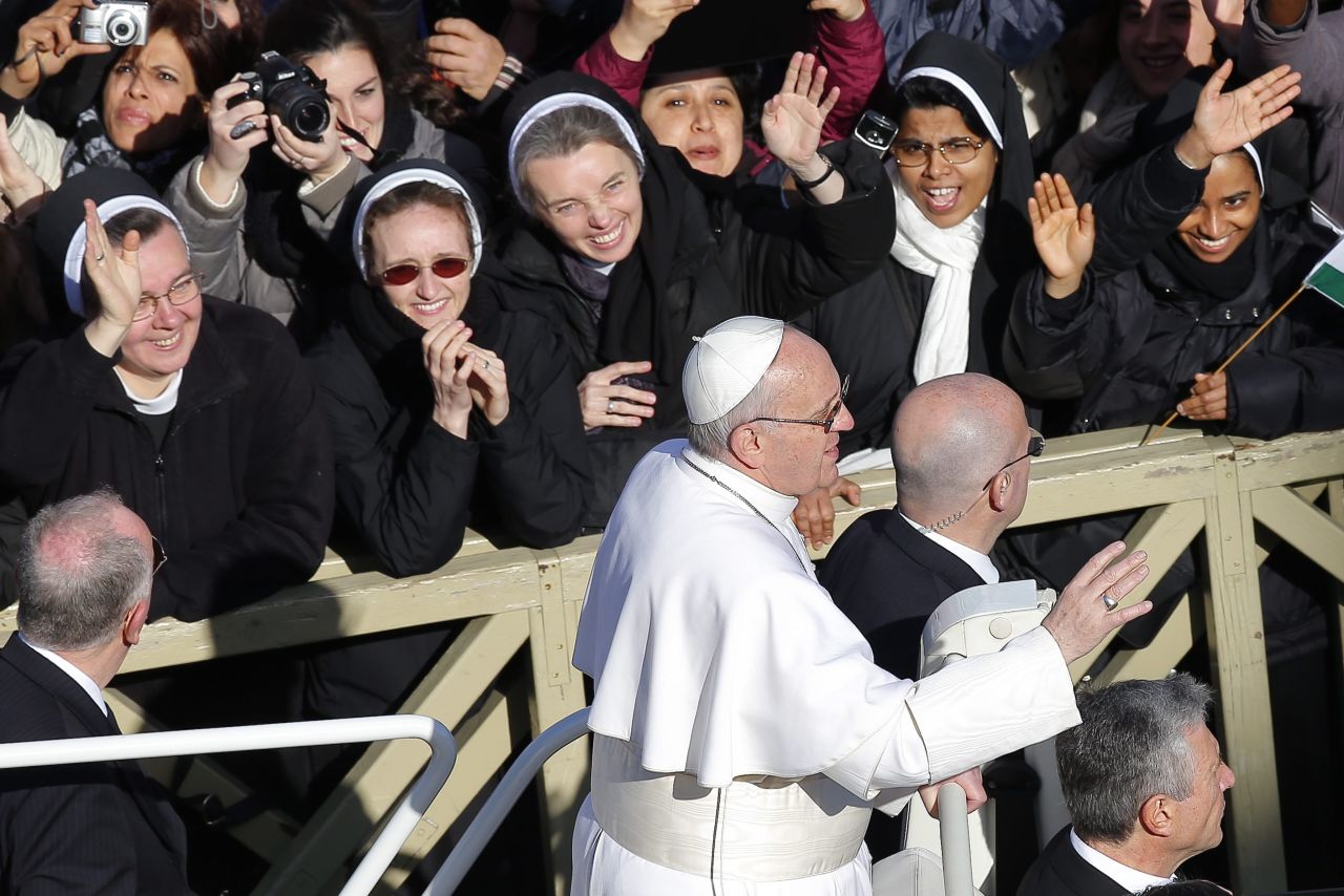 Nuns wave to Pope Francis upon his arrival at the square.
