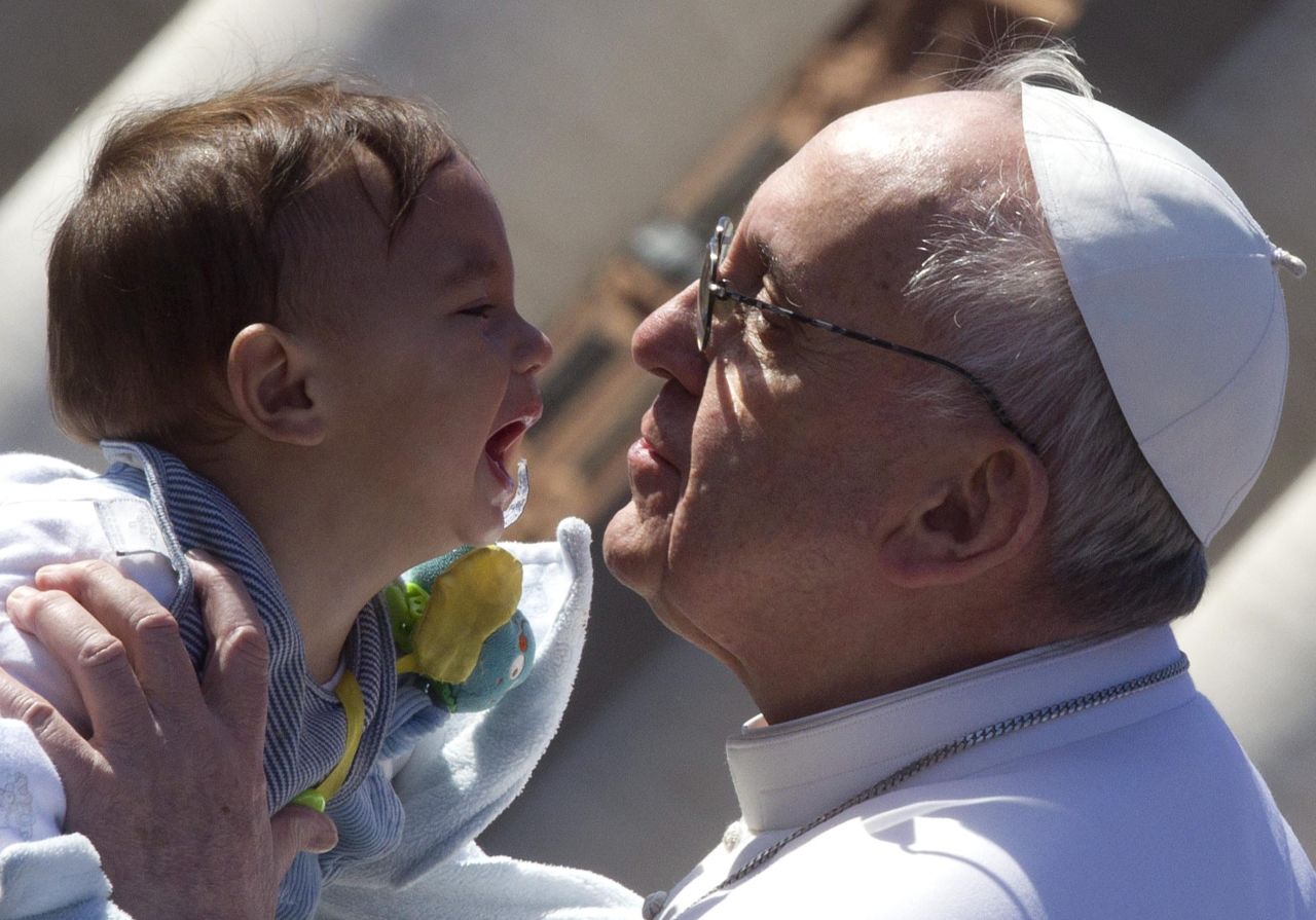 Francis prepares to kiss a child.