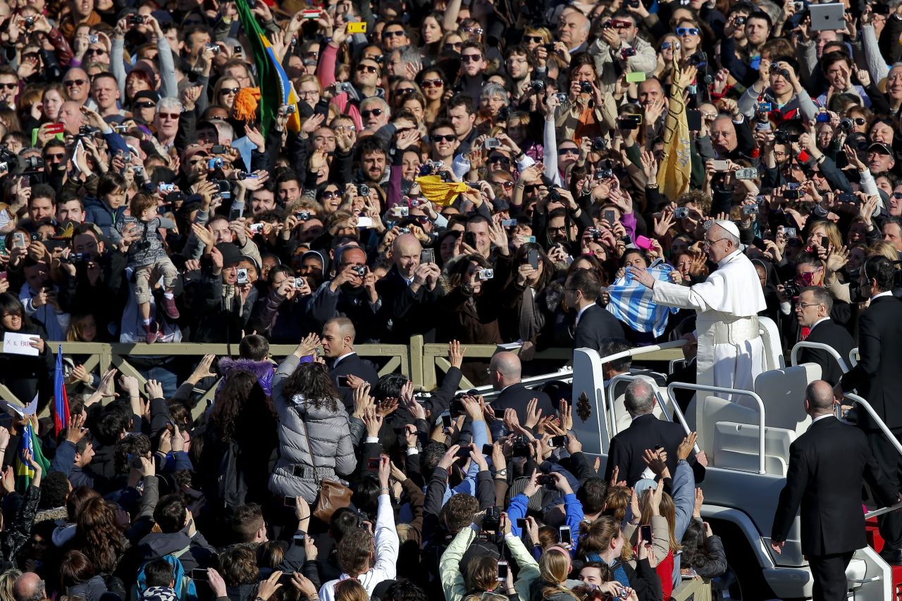 Pope Francis greets crowds as he arrives at St. Peter's Square.