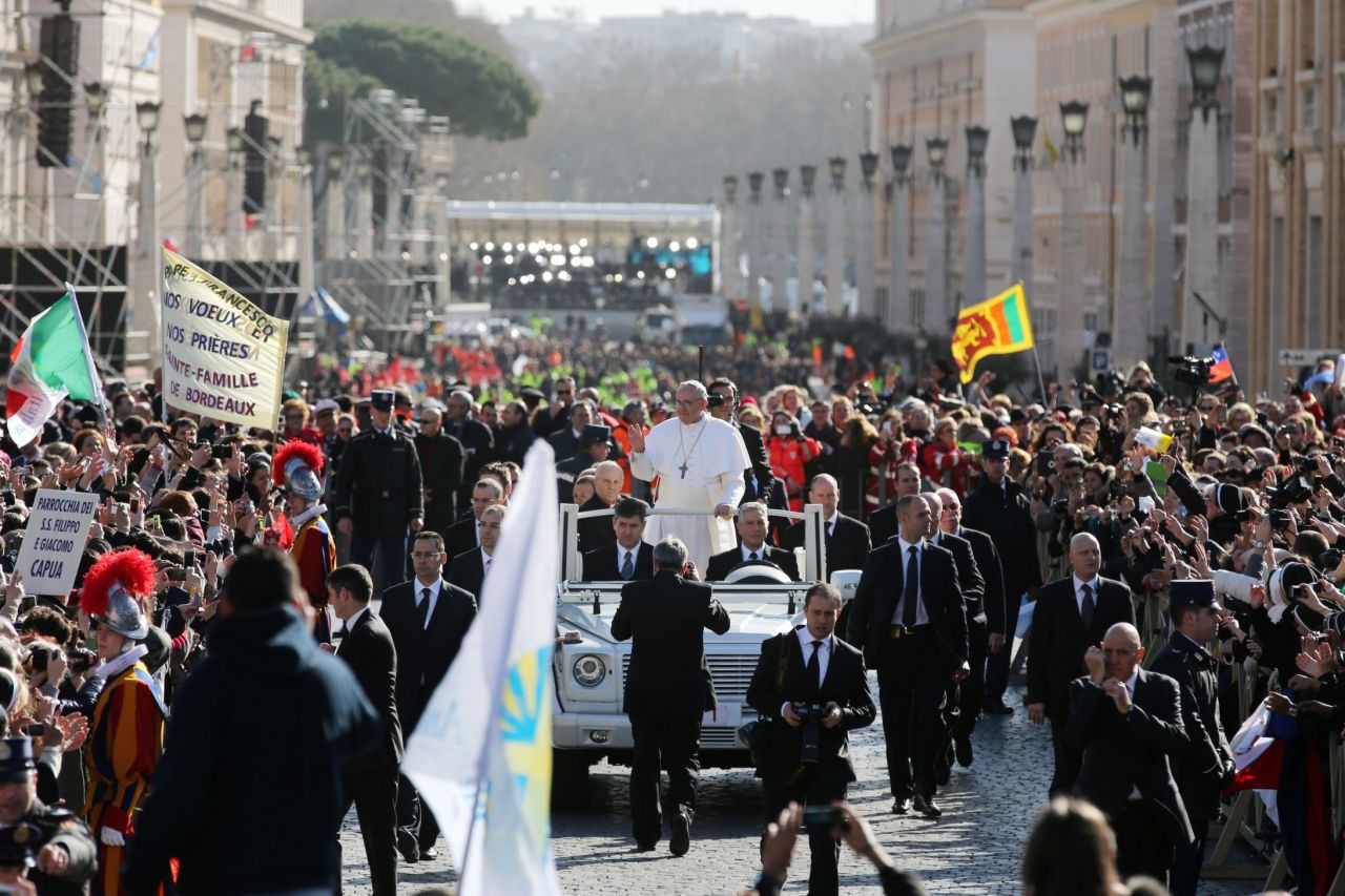 Pope Francis rides through the throngs of faithful in St. Peter's Square. He circled the square in an open-top vehicle, bypassing the Popemobile with its bulletproof glass.
