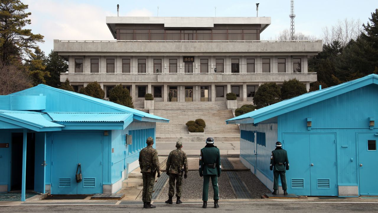 South Korean soldiers stand guard as a North Korean soldier, far center, looks on at the truce village of Panmunjom in the demilitarized zone dividing the two Koreas on March 13.