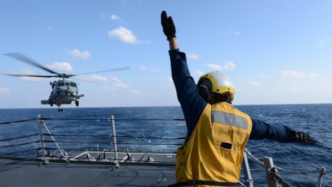 U.S. Navy Boatswain's Mate 3rd Class Brittany Chiles signals to an SH-60B Seahawk helicopter as it lands on the flight deck of the destroyer USS McCampbell on March 4 in the Pacific Ocean, in this Navy handout photo.