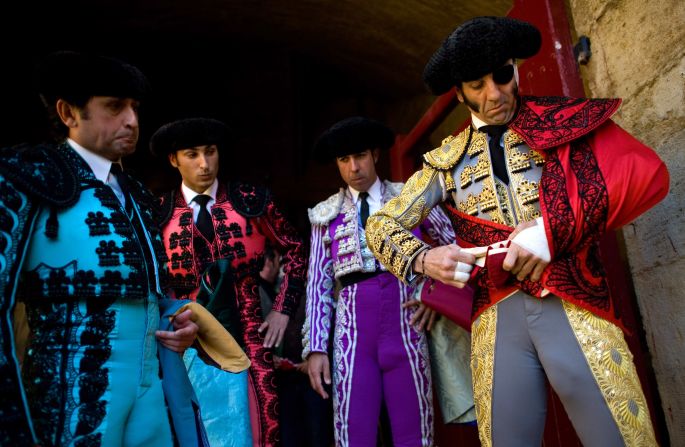 Bullfighter Juan Jose Padilla, right, puts on his costume with help from his assistants before a bullfight that's part of the festival on March 18.