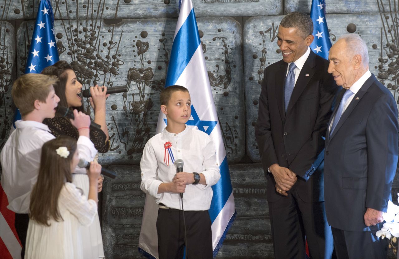 Obama and Peres listen to children sing before meeting on March 20.