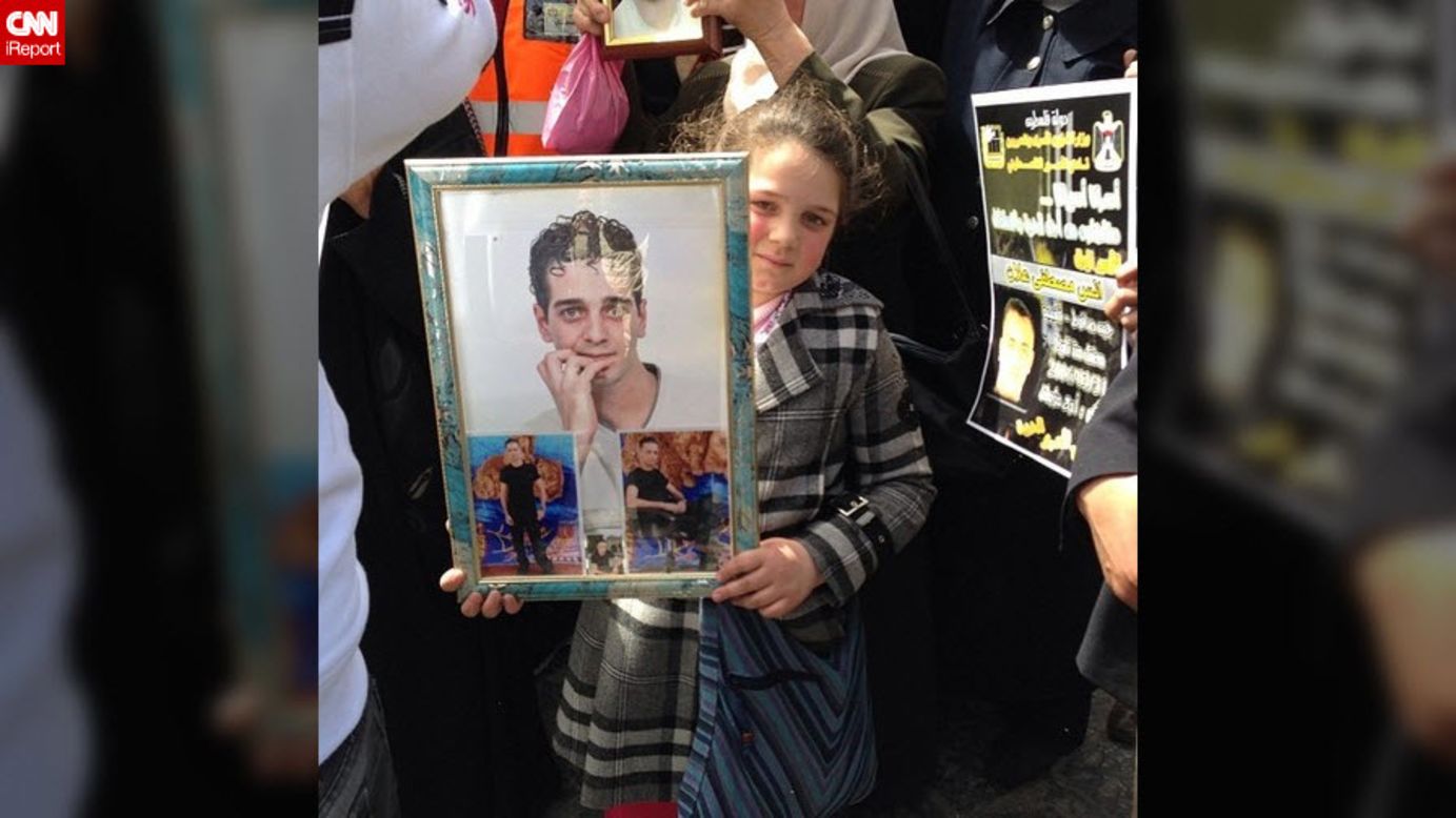 In the West Bank, a girl holds images of a loved one at a protest demanding the release of Palestinians detained in Israel.