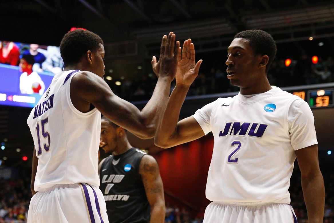 Ron Curry and Andre Nation of the James Madison Dukes celebrate as time winds down against LIU Brooklyn on March 20.
