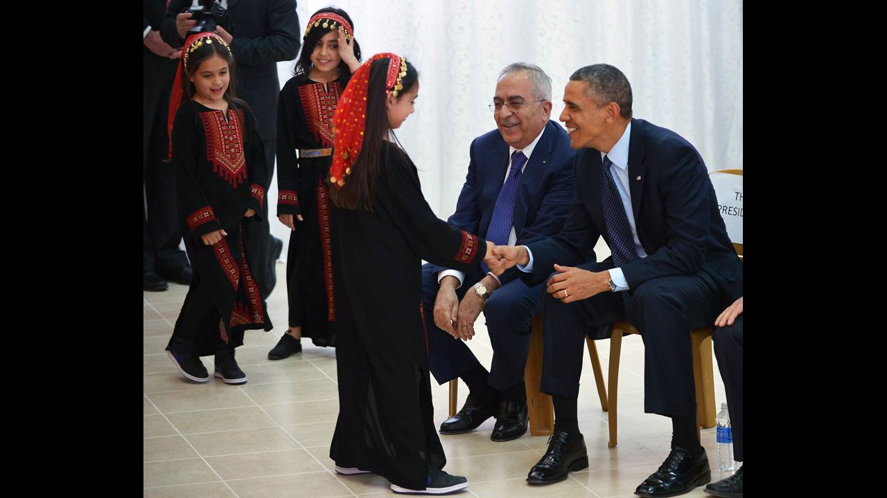Obama and Salam Fayyad, prime minister of the Palestinian Authority, greet a young dancer following a performance at the al-Bireh Youth Center in Ramallah on March 21.