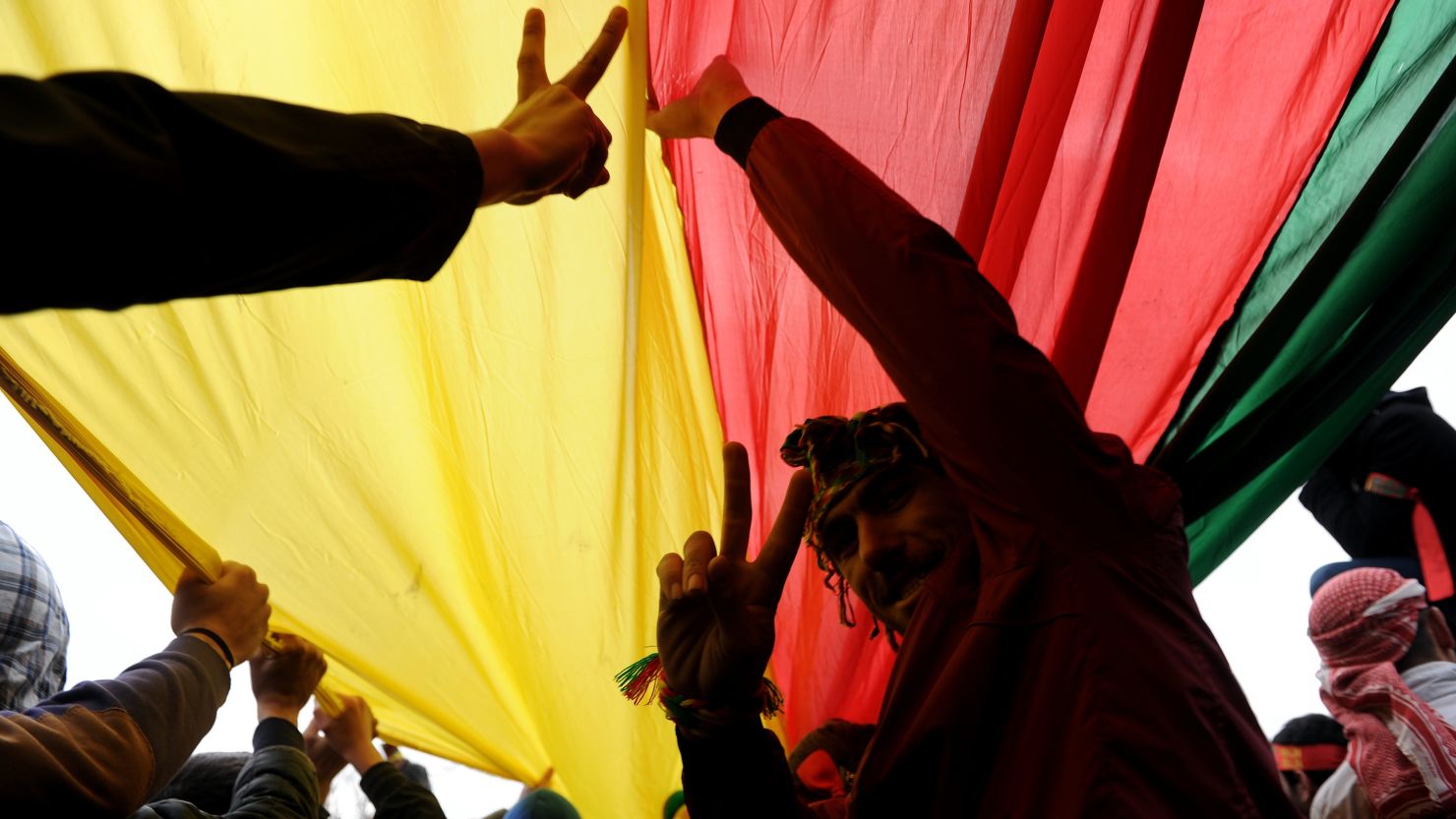 Kurds hold a giant flag of PKK (Kurdish Workers Party) and flash V-signs during celebrations on March 17, 2013 of Nowruz, the Persian New Year festival, in Kazlicesme, Istanbul.