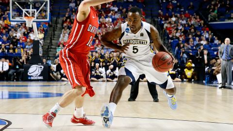 Junior Cadougan of the Marquette Golden Eagles drives against Nik Cochran of the Davidson Wildcats on March 21 in Lexington, Kentucky. 