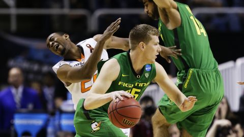 Arsalan Kazemi of Oregon, No. 14, is called for an offensive foul on Markel Brown of Oklahoma State as E.J. Singler of Oregon drives down court on March 21.