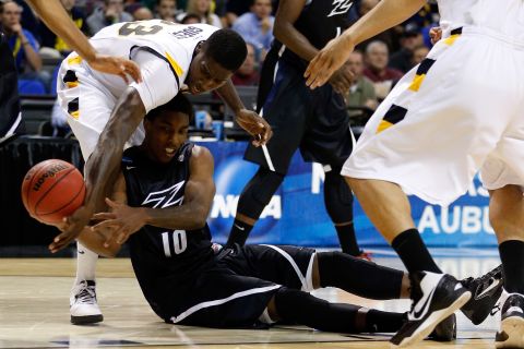 Nick Harney of Akron looks to pass the ball from the ground against Jarred Guest of VCU on March 21.
