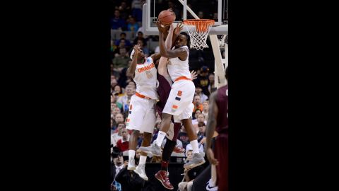 Rakeem Christmas, right, and C.J. Fair, left, of Syracuse go for a rebound against Eric Hutchison of Montana on March 21.