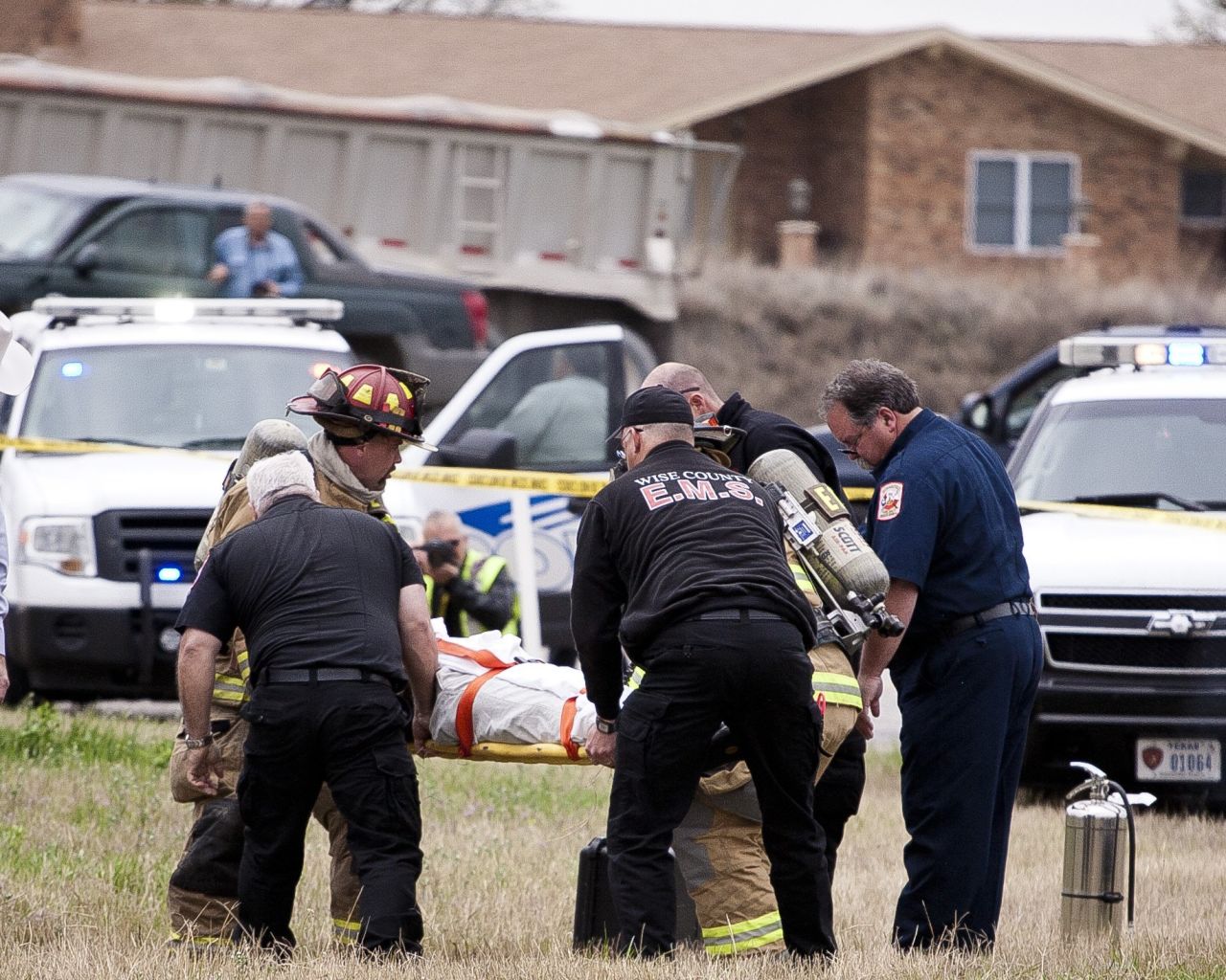 Firefighters and emergency workers carry Ebel to a waiting ambulance. He later died.