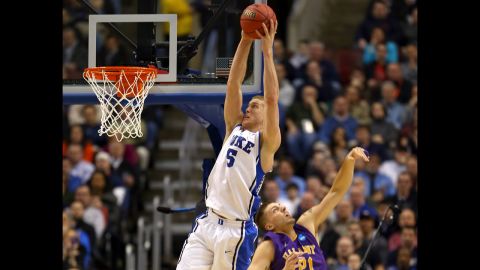 Mason Plumlee of the Duke Blue Devils, left, catches a pass for a dunk over Blake Metcalf of the Albany Great Danes on March 22.