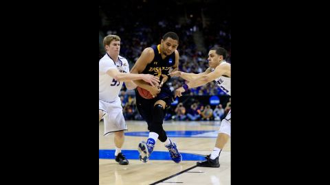 Tyreek Duren of the La Salle Explorers, center, tries to maintain possession of the ball as he drives against Will Spradling, left, and Angel Rodriguez of the Kansas State Wildcats on March 22.