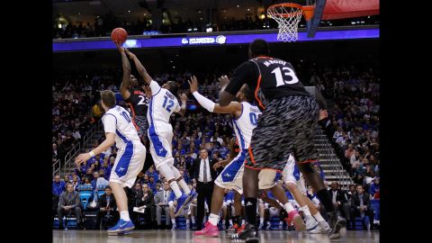 Sean Kilpatrick of the Cincinnati Bearcats, second from left, shoots over Jahenns Manigat of the Creighton Bluejays on March 22.