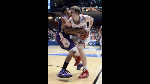 Cody Zeller of the Indiana Hoosiers, right, handles the ball against Charles Cooke of the James Madison Dukes on March 22.