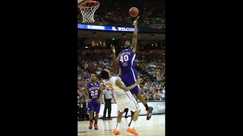 Marvin Frazier of the Northwestern State Demons, center, goes up to the basket over Mike Rosario of the Florida Gators on March 22.