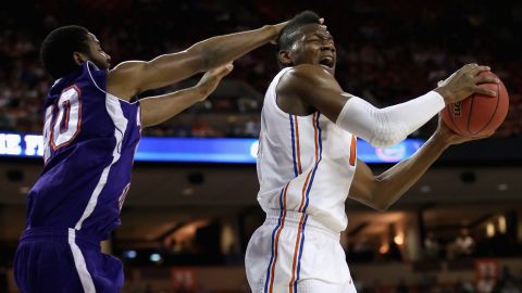 Will Yeguete of the Florida Gators, right, controls the ball against Marvin Frazier of the Northwestern State Demons on March 22.