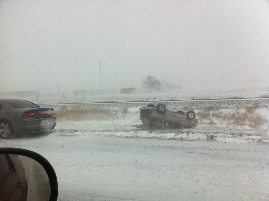 A car lies flipped after an accident on Interstate 25 near Pueblo, Colorado, on Saturday.