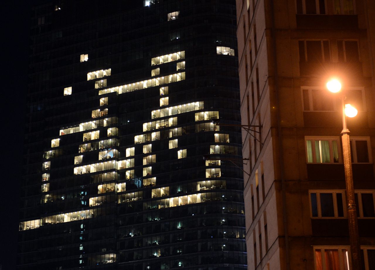 Some of the offices of a building have the lights on to shape a bicycle in downtown Warsaw.