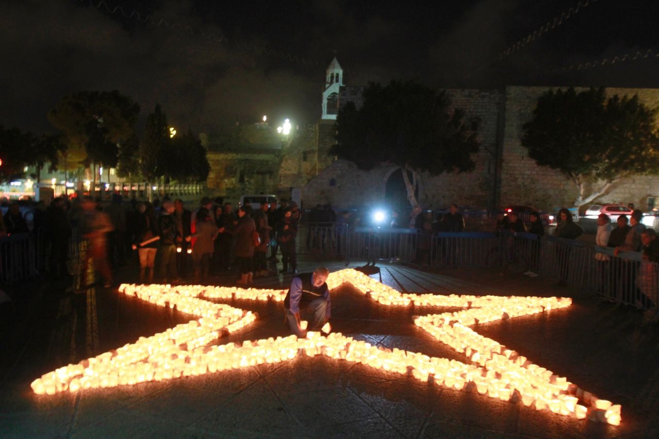 Members of Palestine Wildlife Society outline the star of Bethlehem with candles at the Manager Square in front of the Church of the Nativity in the West Bank town of Bethlehem on March 23 to mark the Earth Hour for the first time in Palestine.