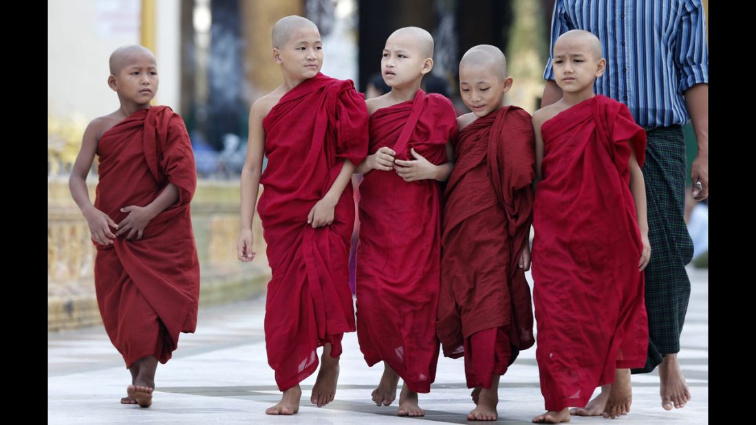Young Buddhist monks walk on their daily alms collection at the sacred golden Shwedagon Pagoda in Yangon.