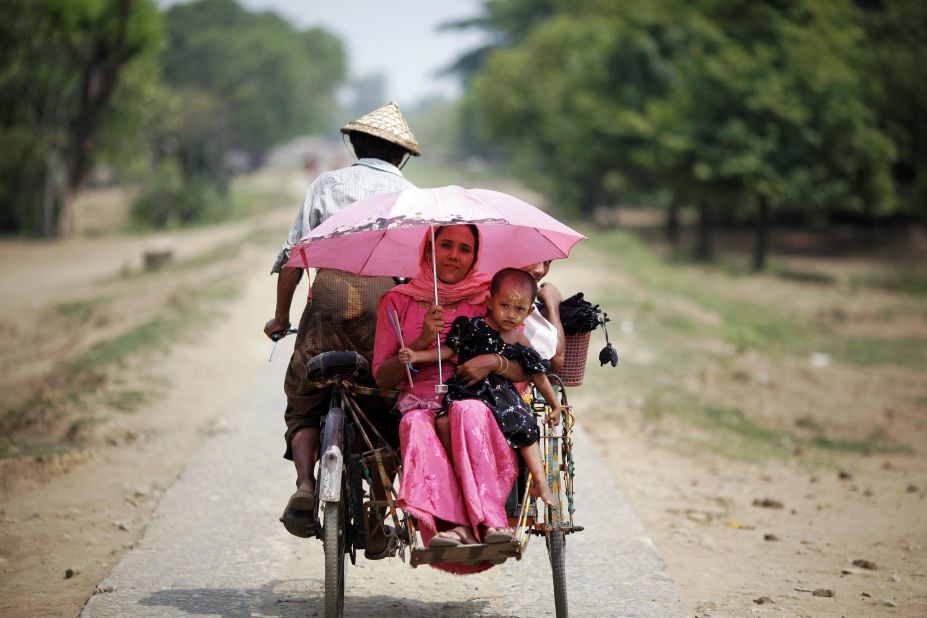People ride in a rickshaw on a road north of the town of Sittwe.