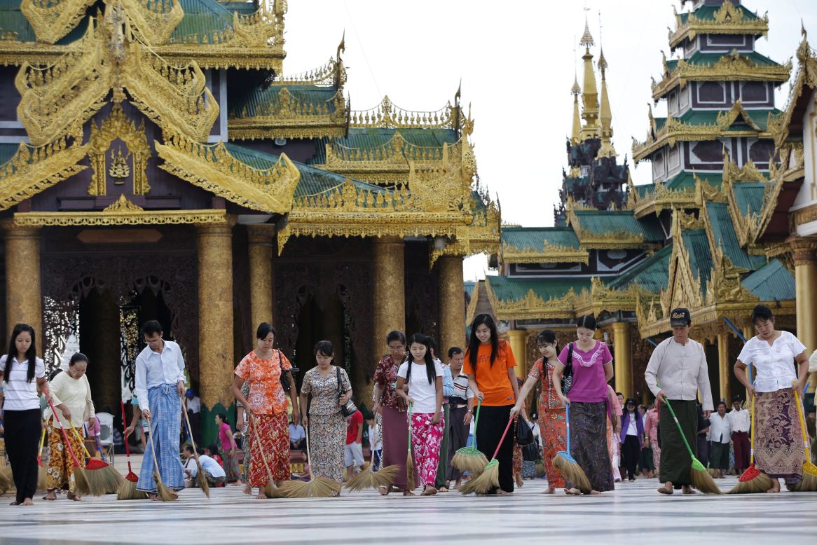 Volunteers sweep the floors at the golden Shwedagon Pagoda in Yangon.
