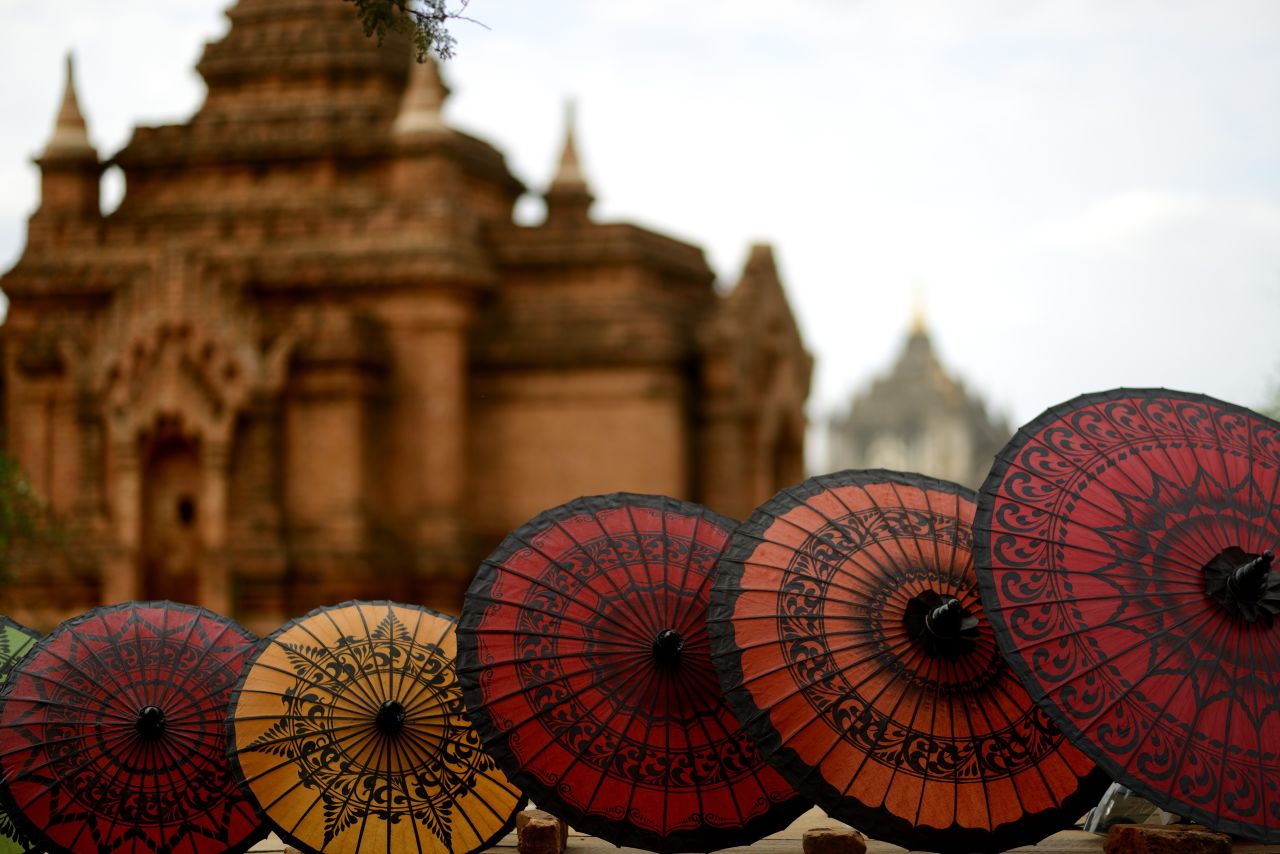 A line of umbrellas sits in front of an old building in Bagan.