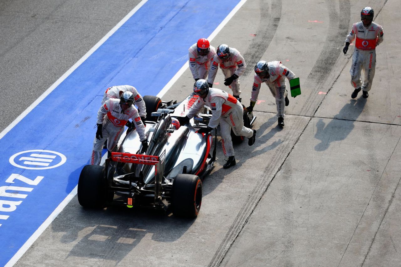 Jenson Button's car is pushed back to the pit area after his crew let the McLaren leave with a loose front wheel. It ruined the 2009 world champion's chances of earning points and he retired before the end of the race. However, his new Mexican teammate Sergio Perez finished ninth.