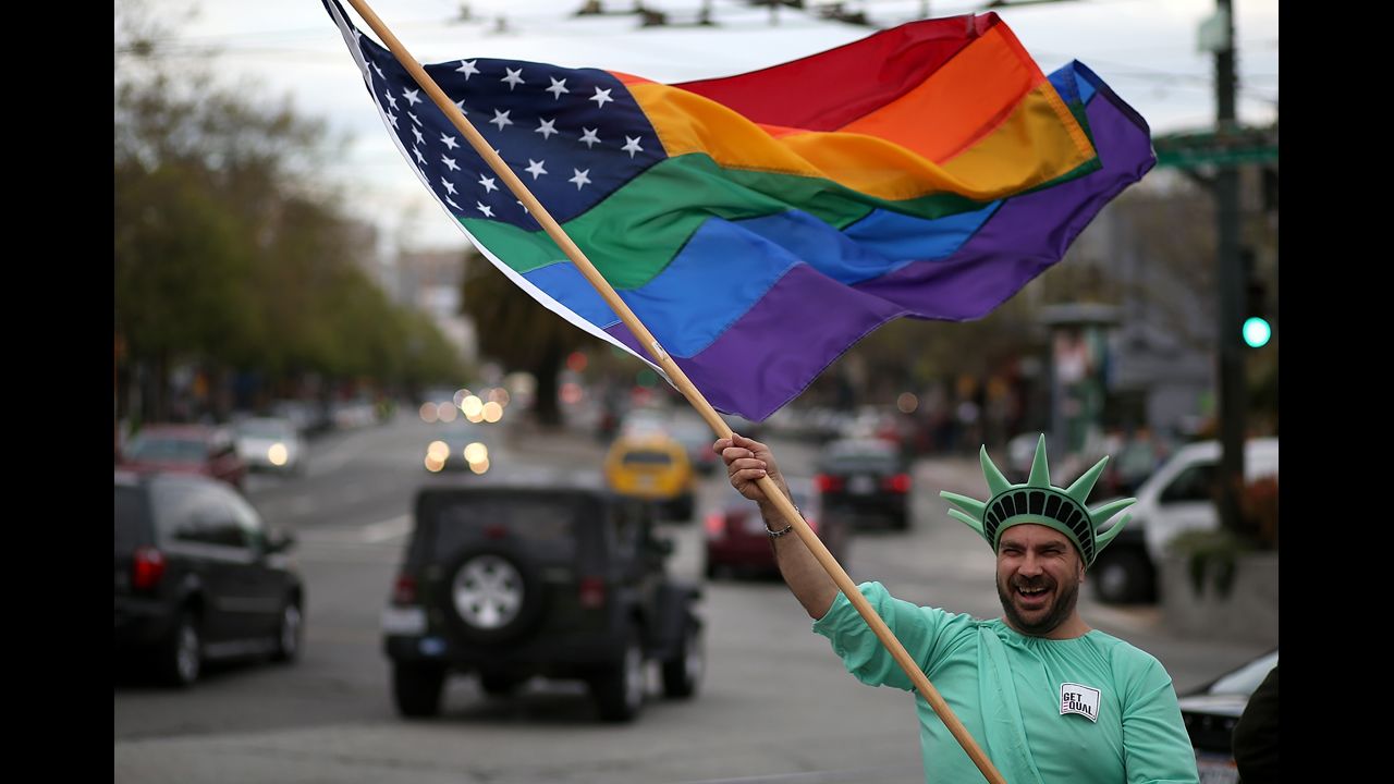 Nikolas Lemos waves a rainbow flag during the March 25 rally in San Francisco.