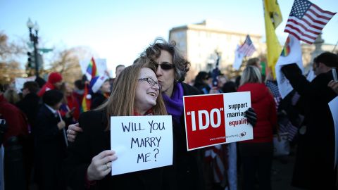 Andrea Grill, right, and Lee Ann Hopkins from Alexandria, Virginia, embrace after becoming engaged during a rally Tuesday.