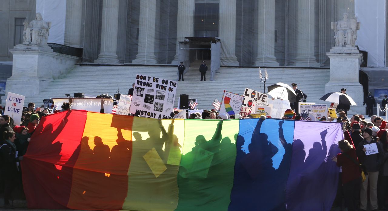 Anti-Proposition 8 protesters are shadowed by a rainbow banner on Tuesday.