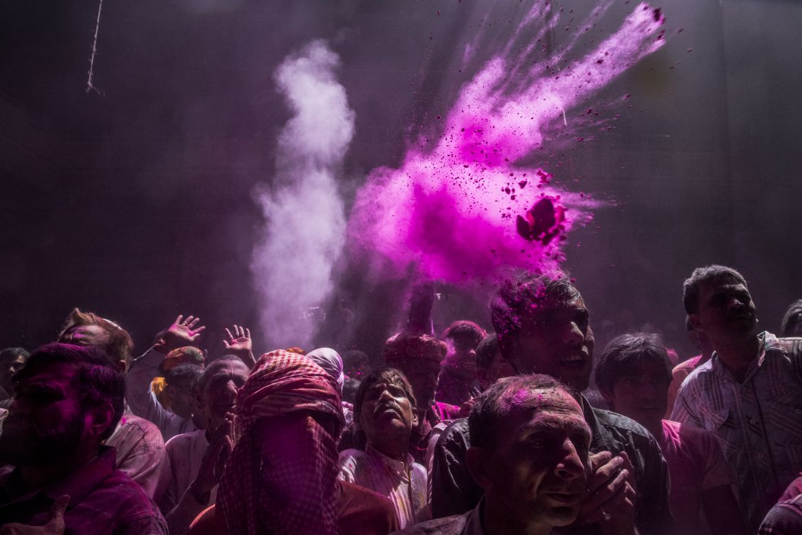 Hindu devotees throw colored powder, known as gulal, during early Holi celebrations at the Banke Bihari temple on Tuesday, March 26, in Vrindavan.